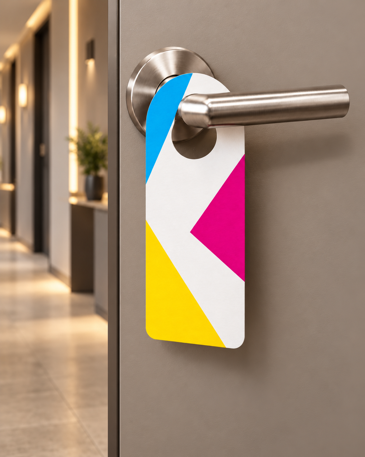 Türhänger im CMYK-Design an einer silbernen Klinke in einem modernen Hotel